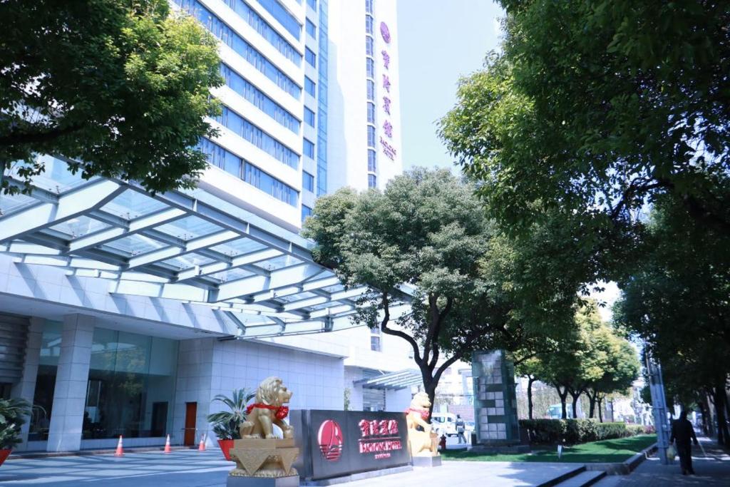 a building with a sign in front of it at Baolong Hotel Shanghai in Shanghai