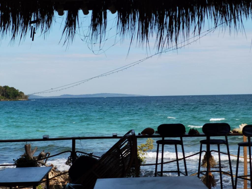 a view of the ocean from a beach with chairs at Dreamer of the sea in Koh Rong Sanloem