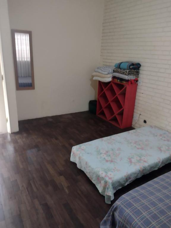 a room with a bed and a table with a mattress at Hostel Aruanda in Belo Horizonte