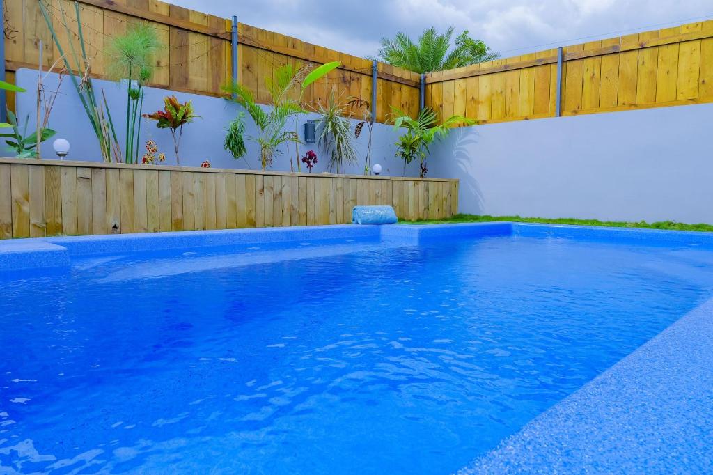 ein Pool mit einem Zaun und blauem Wasser in der Unterkunft Villa Idylle quatre etoiles in Rivière