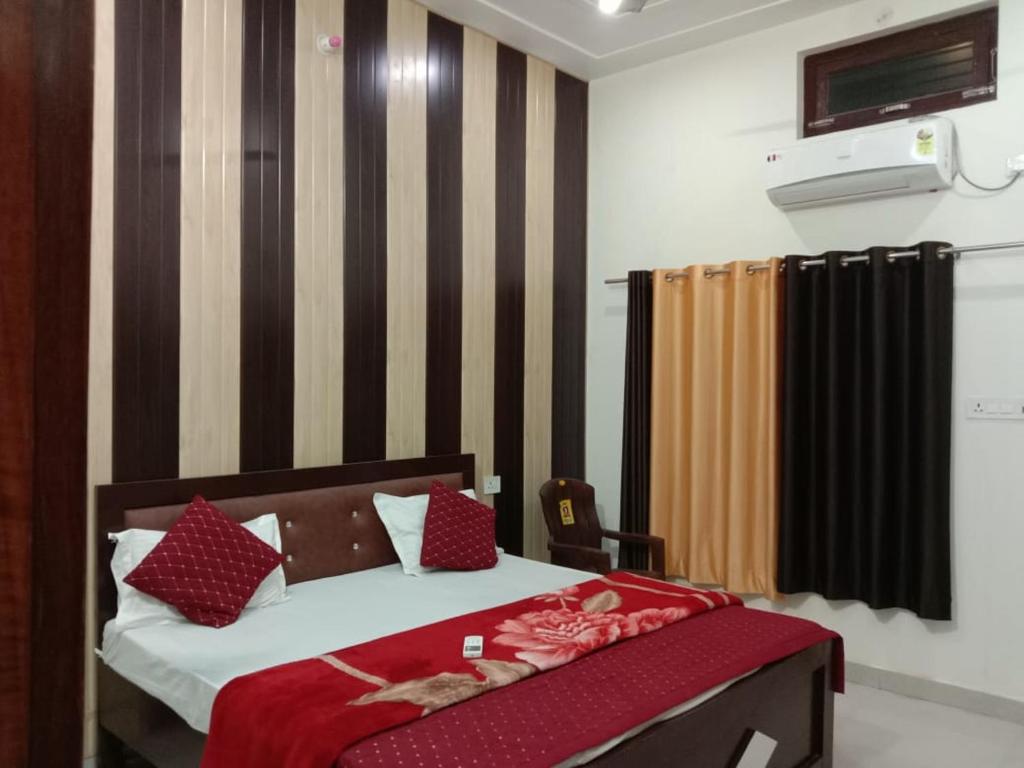 a bedroom with a bed with red pillows at Ramam hotel by Naavagat Ayodhya in Ayodhya