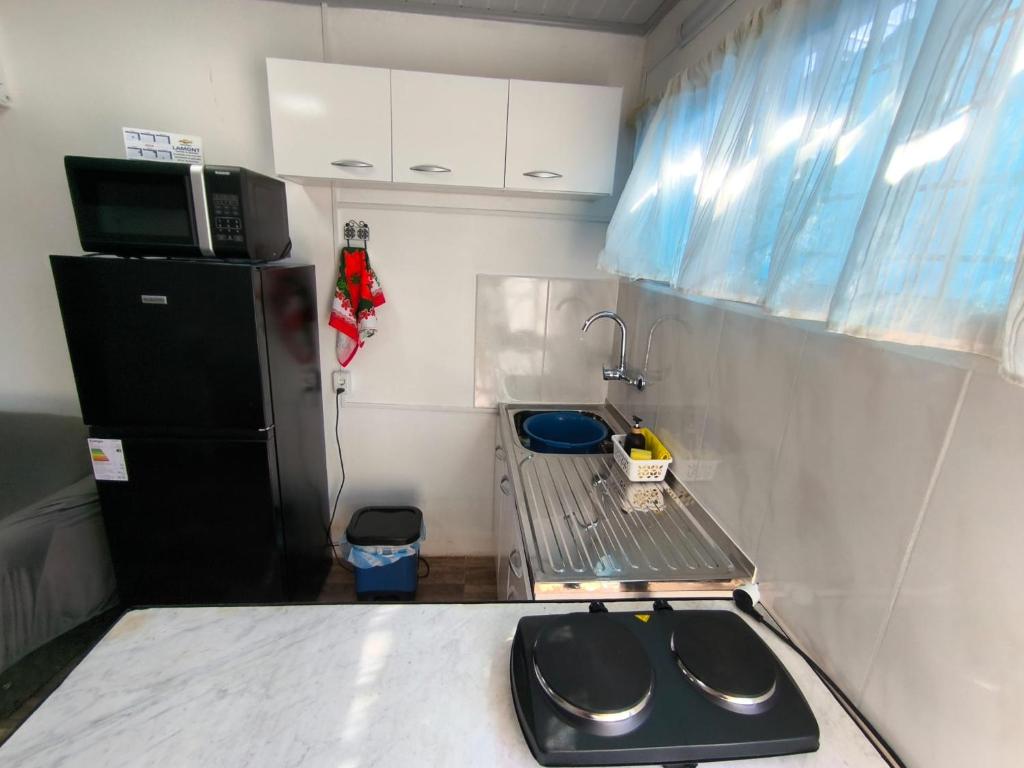 eine kleine Küche mit Spüle und Kühlschrank in der Unterkunft Alojamiento Donatello in Durazno