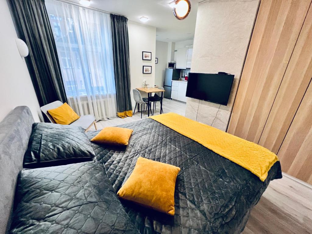 sypialnia z łóżkiem z żółtymi poduszkami w obiekcie Cozy apartments w Rydze