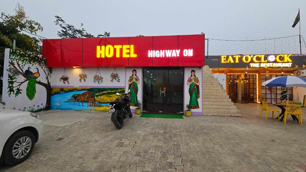 un hotel con una motocicleta estacionada fuera de él en OYO Hotel Highway ON, en Meerut