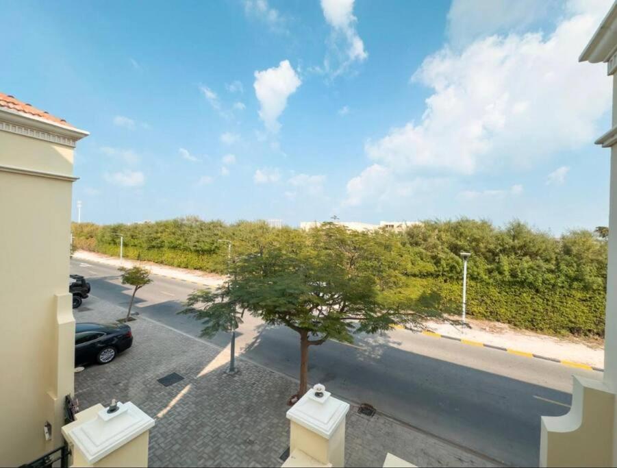 einen Blick aus dem Fenster einer Straße mit einem Baum in der Unterkunft Luxurious three-bedroom Villa. in Ras al Khaimah