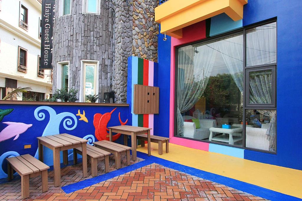 a colorful building with benches and tables in front of it at Yu Sen House in Kenting