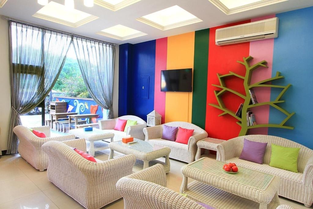 a living room with chairs and a colorful wall at Yu Sen House in Kenting