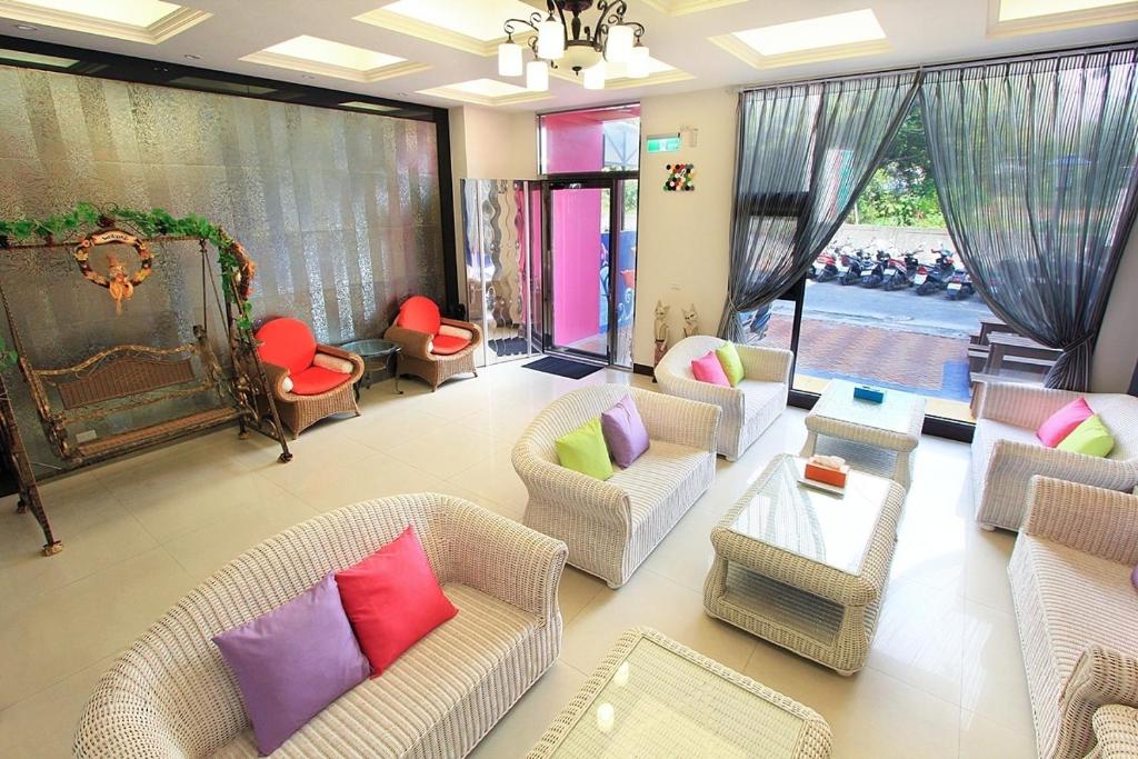 a living room with couches and chairs with colorful pillows at Yu Sen House in Kenting