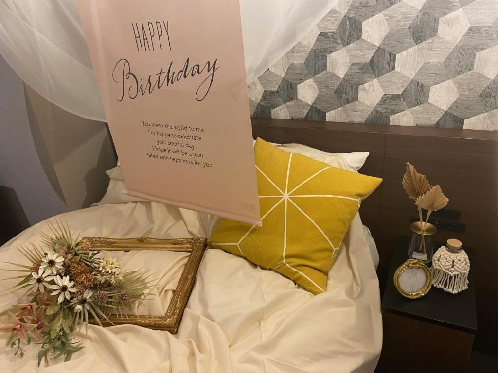 un signo de feliz cumpleaños sentado en la parte superior de una cama en TAPSTAY HOTEL - Vacation STAY 35241v en Saga