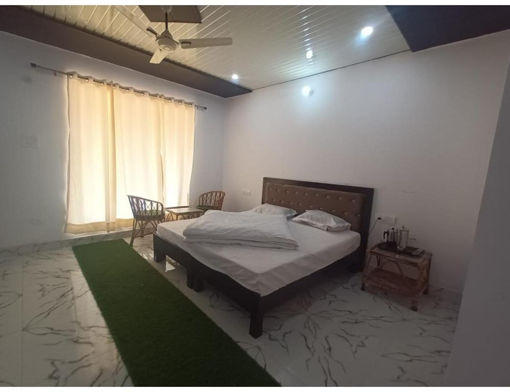 a bedroom with a bed and a table in it at Hotel PJ Dupeex, Ravigram, Phata in Phata