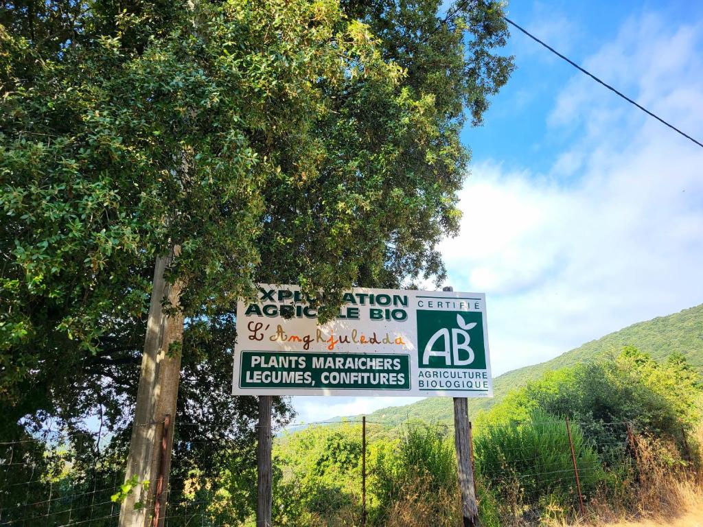 two signs on the side of a road with trees at L anghjuledda 2 in Grosseto-Prugna