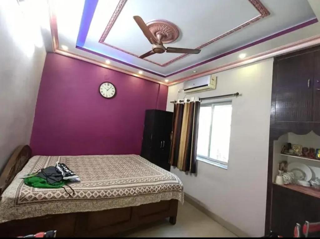 - une chambre avec un lit, un ventilateur de plafond et une horloge dans l'établissement Aparna sarin park, à Kondapur
