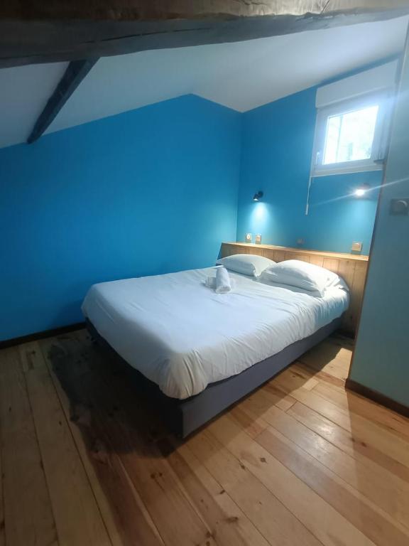 um quarto azul com uma cama com uma parede azul em Le gîte du Vivier - Loches em Loches