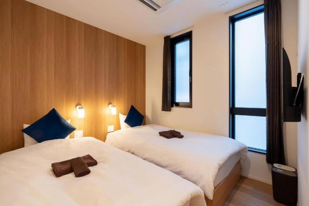 um quarto de hotel com duas camas e uma janela em ZONE SHINSAIBASHI WEST em Osaka