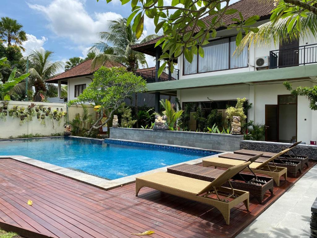 a swimming pool in front of a house at Putri Ayu Cottages in Ubud