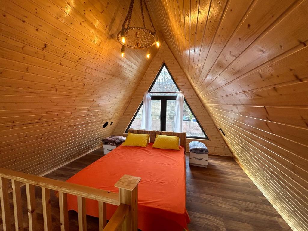 ein Schlafzimmer mit einem Bett in einem Holzhaus in der Unterkunft A Frame Lankaran in Länkäran