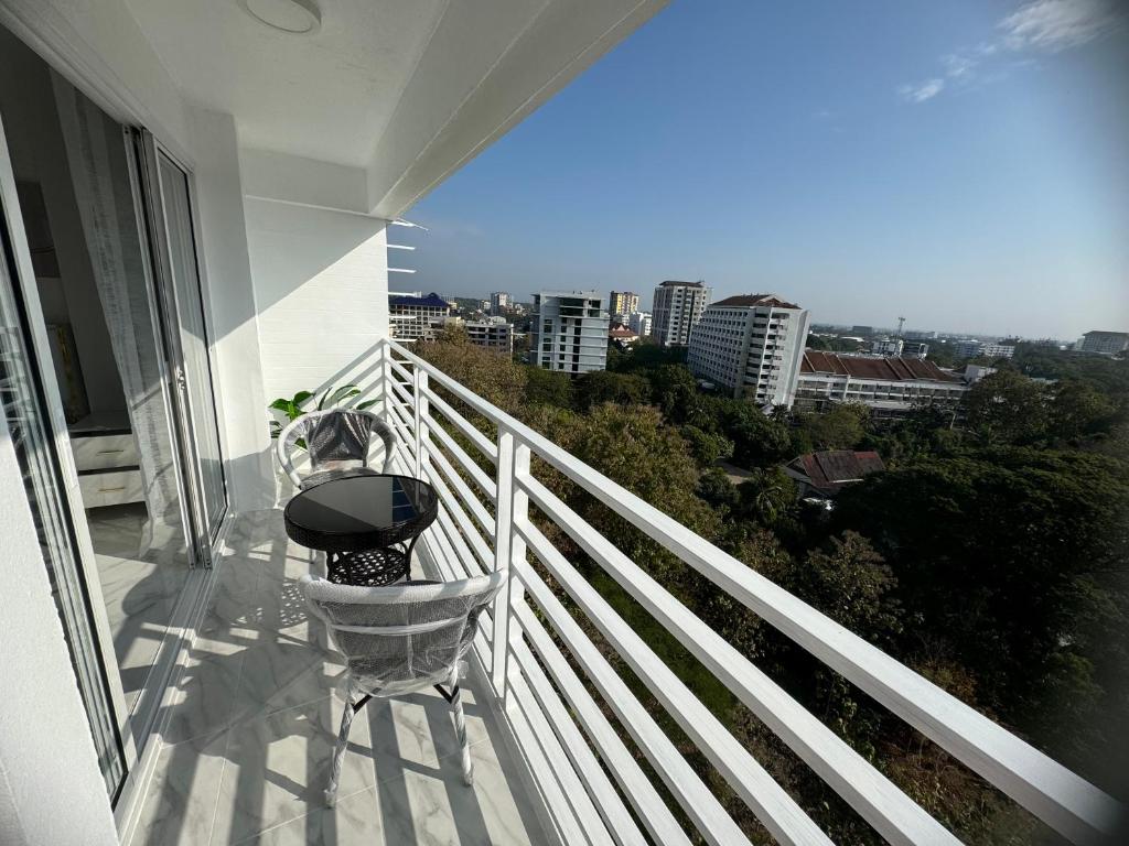 een balkon met een stoel en uitzicht op de stad bij Ningman Road Apartment in Chiang Mai