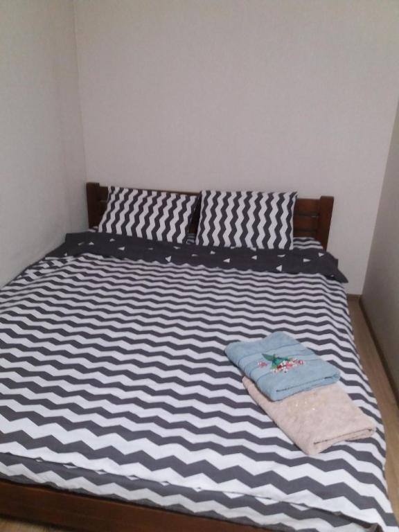 uma cama com lençóis e almofadas listradas em preto e branco em ПРОСТОРНАЯ СОЛНЕЧНАЯ ДВУХКОМНАТНАЯ квартира em Khmelʼnytsʼkyy