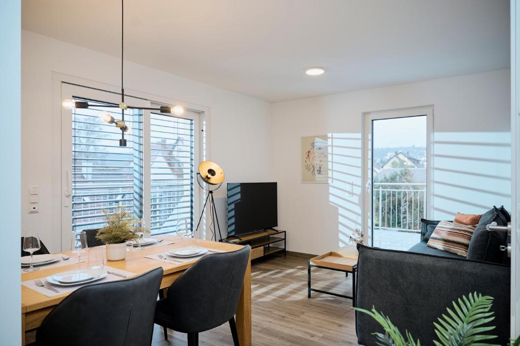 a dining room with a table with chairs and a television at Rent4Living Apartments WLAN I kostenfreie Tiefgarage I Therme 5 Minuten zu Fuß I Barrierearm in Bad Kissingen