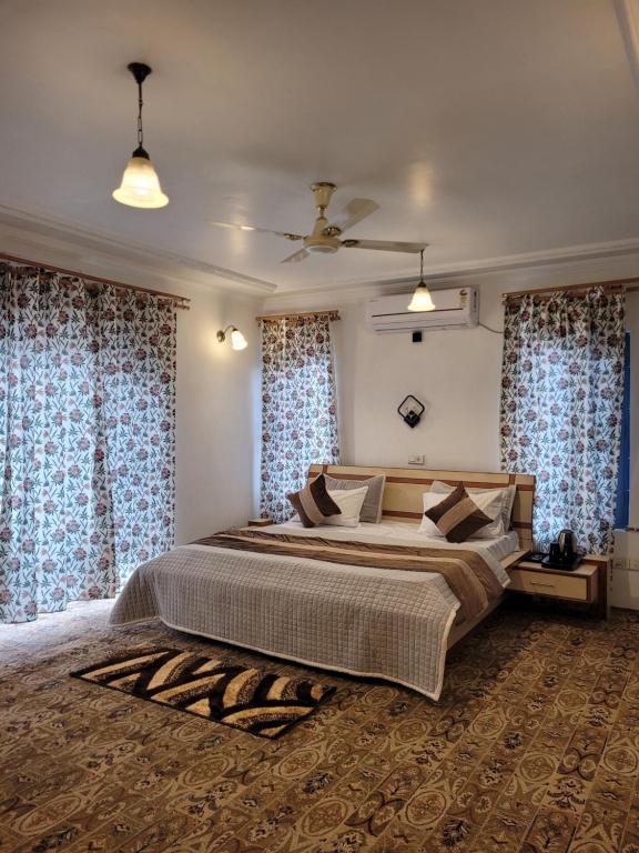 een slaapkamer met een groot bed en blauwe gordijnen bij The Bayt in Srinagar