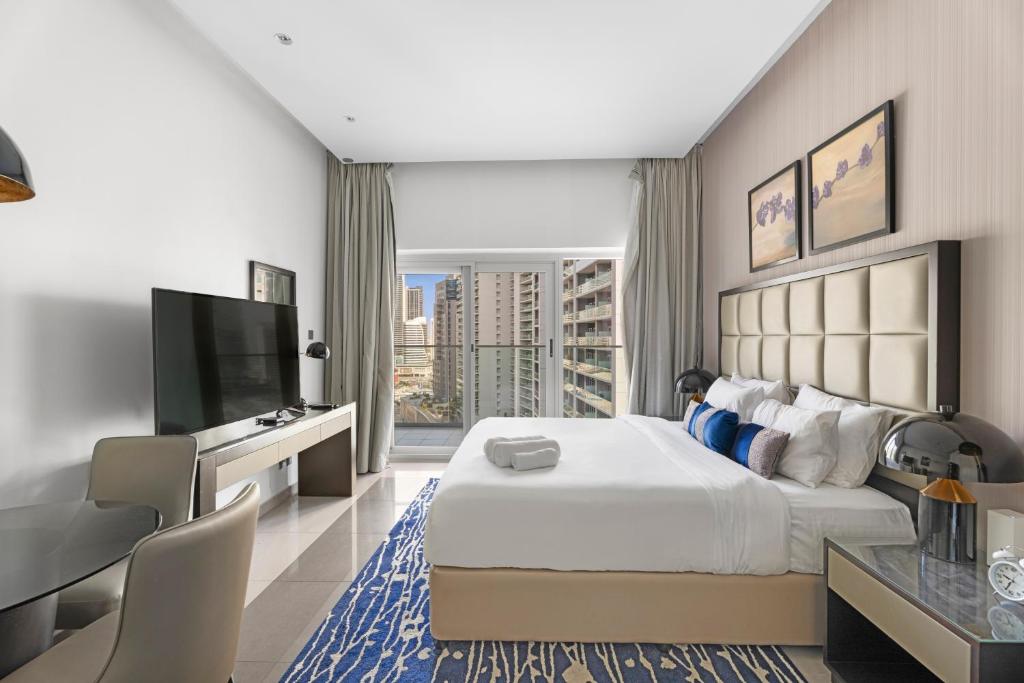 a hotel room with a large bed and a flat screen tv at Lovely Studio in Business Bay in Dubai