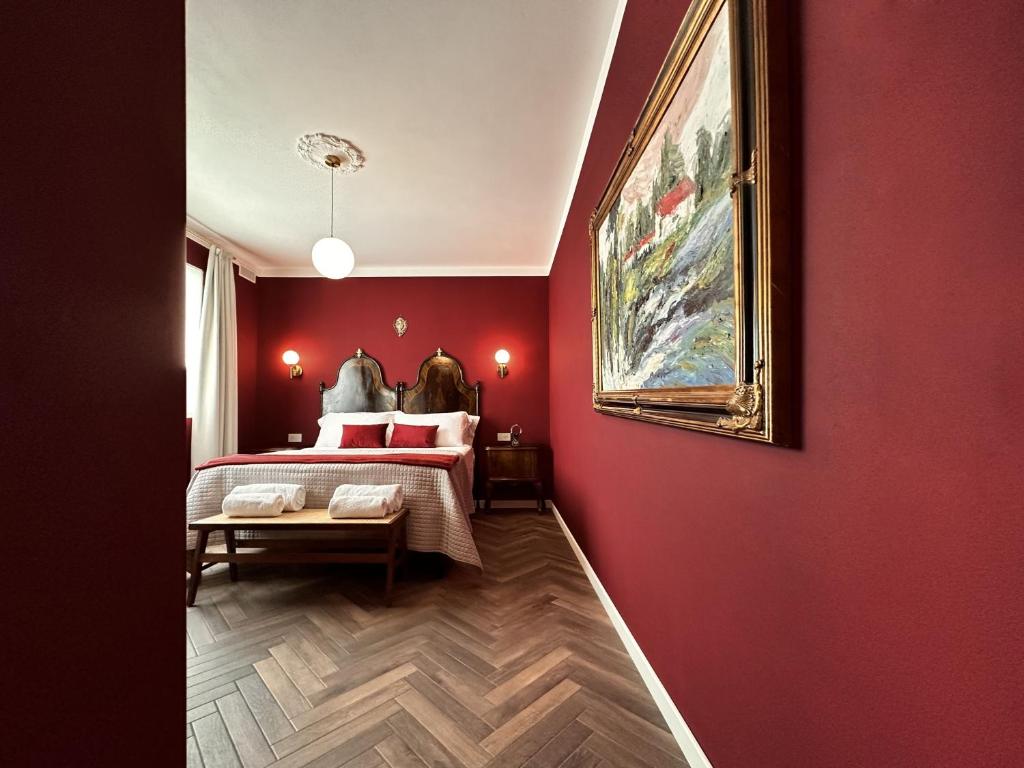 una camera rossa con un letto e un dipinto sul muro di Villa Danilla a Salzano