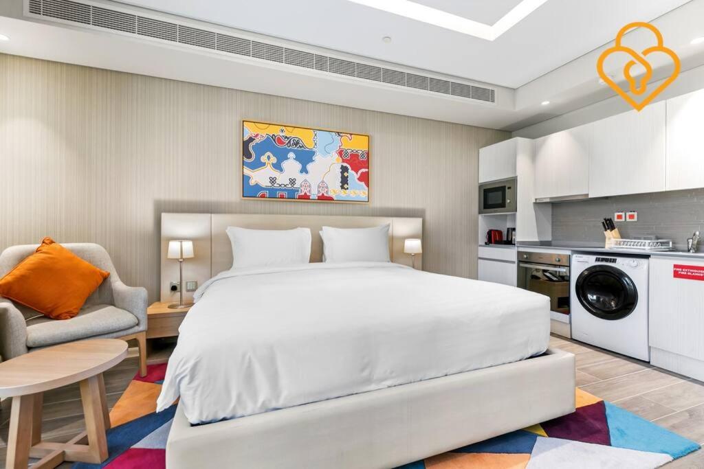 Cet appartement comprend une chambre avec un grand lit blanc et une cuisine. dans l'établissement Keysplease Modern Studio Near Beach , Murjan JBR 601, à Dubaï