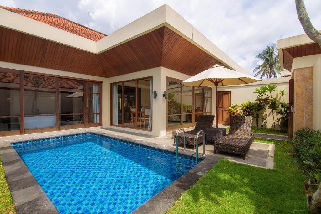a villa with a swimming pool and a house at Champlung Sari Villa & Spa Ubud in Ubud