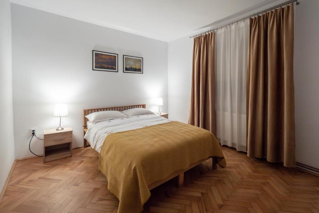 a bedroom with a bed and a table with two lamps at Casa Ryu in Cluj-Napoca