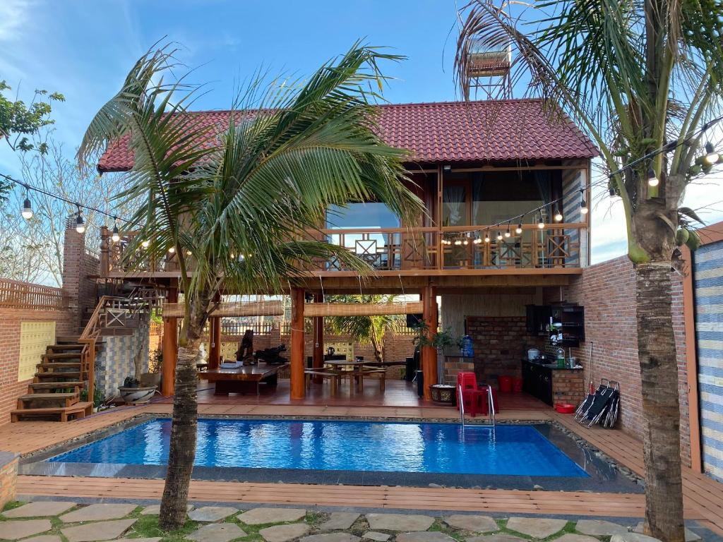 ein Haus mit einem Pool vor einem Haus in der Unterkunft THE LAND OF LOVE Homestay - Venuestay in Dak Lak