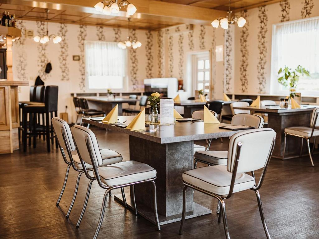 um restaurante com um bar com cadeiras e mesas em REBENTISCH - HOTEL Ferienwohnungen Restaurant em Hasselfelde