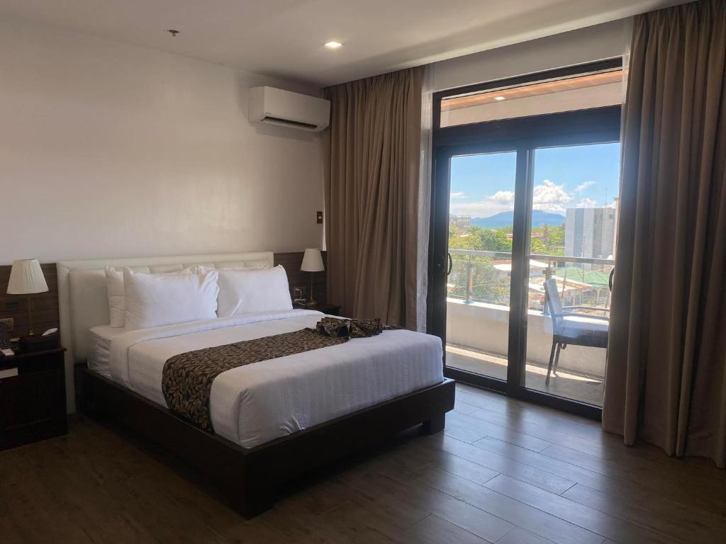 a hotel room with a bed and a large window at Red Iron Hotel in Calbayog