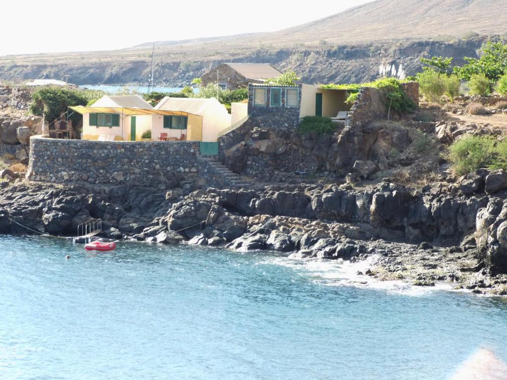 a red boat in the water next to some houses at Casa Tartaruga in Carriçal