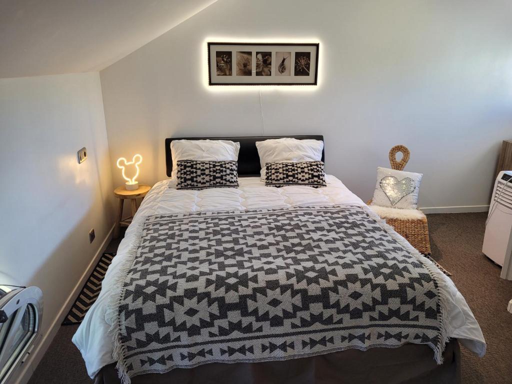 um quarto com uma cama com um edredão preto e branco em Carnetin Le Parc, Gite et B&B em Thorigny-sur-Marne