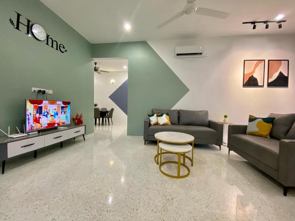 a living room with two couches and a tv at IPOH LYL EVERGREEN HOMESTAY in Ipoh