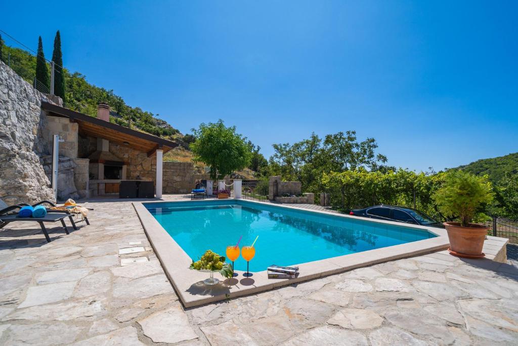 a swimming pool in a yard with a villa at Villa Stone House Kuna in Pridvorje