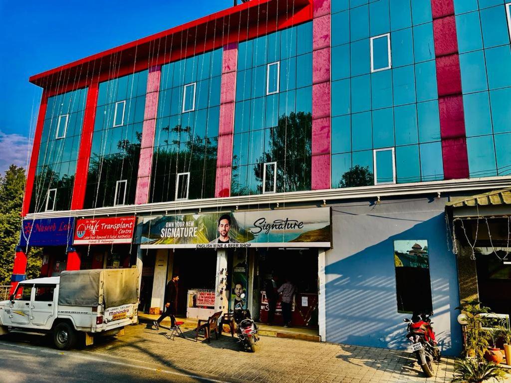 un edificio con un camión estacionado frente a él en Hotel Suryadev en Pālampur