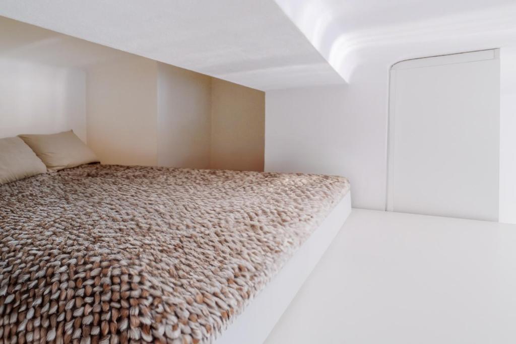 a bedroom with a bed in a white room at Castle Proximity Suite by Rentez in Prague