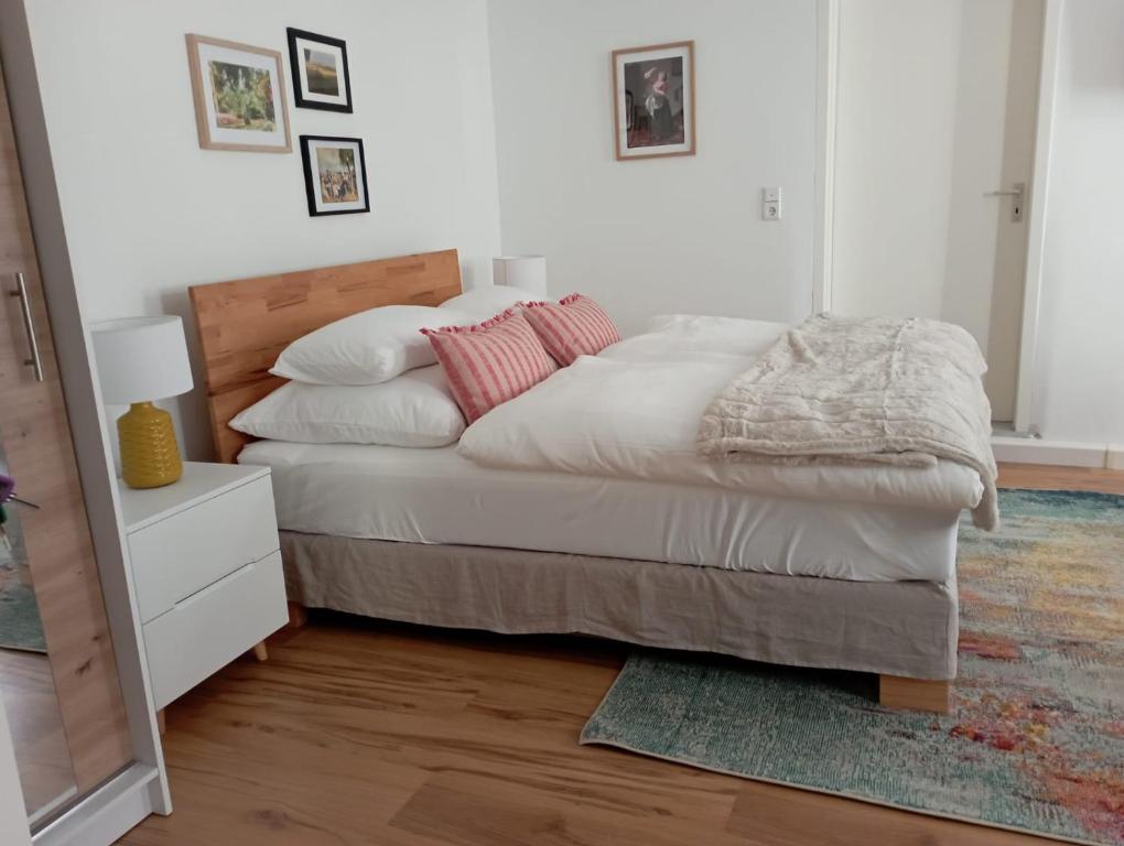 a bedroom with a bed with white sheets and pink pillows at Schenkgasse 4 in Amorbach