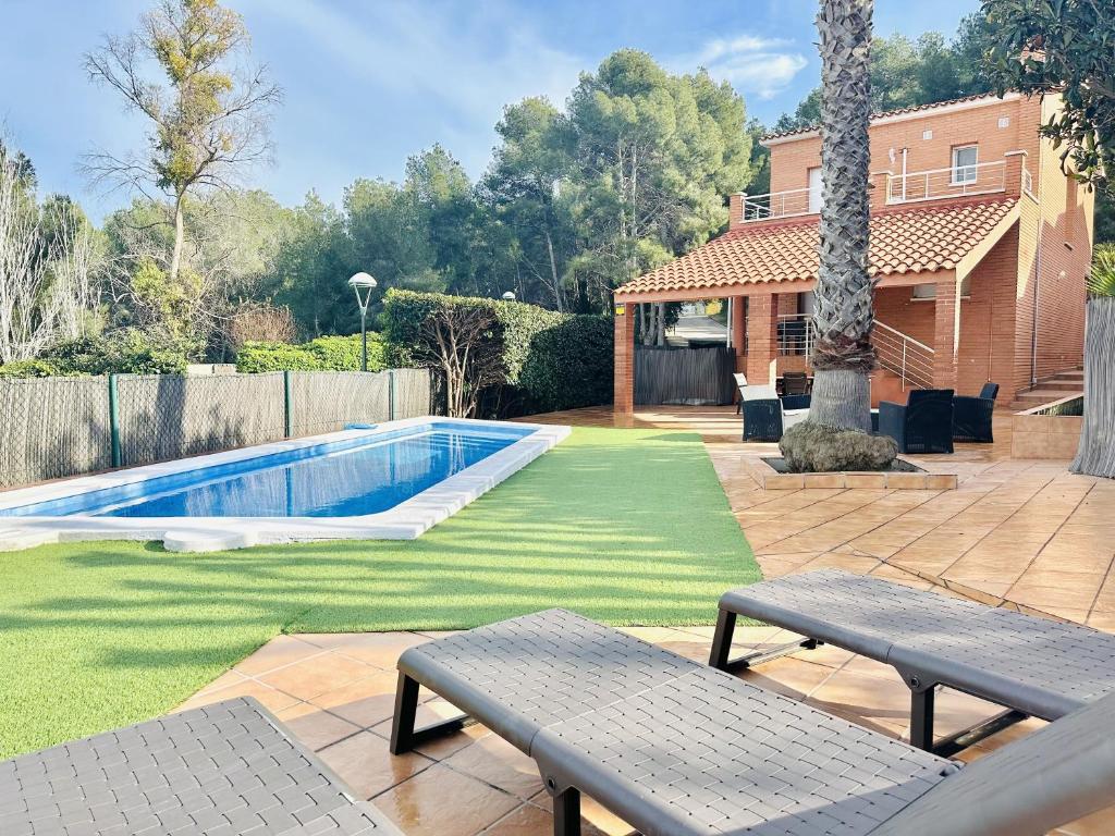 a backyard with a swimming pool and two benches at Villa Mora 2 Pool Oasis in La Mora