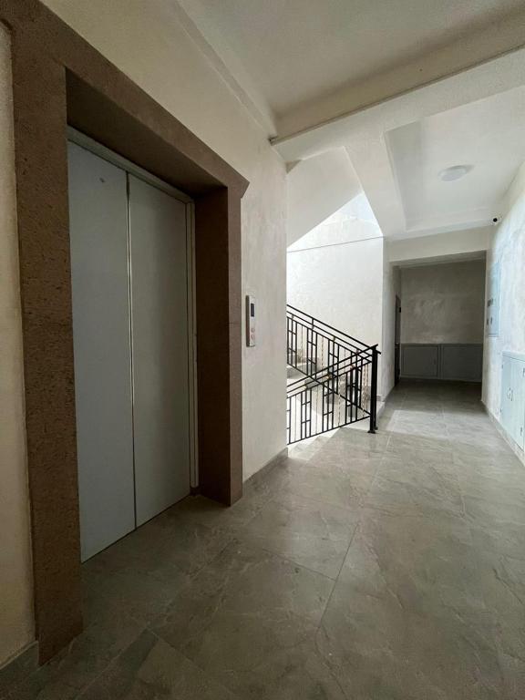 ein leeres Zimmer mit einer Tür und einer Treppe in der Unterkunft Уметалиева in Bischkek