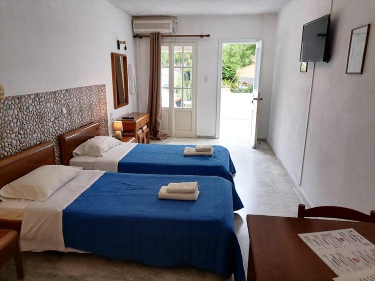 Habitación de hotel con 2 camas y toallas. en Katerina Apartments en Kalymnos
