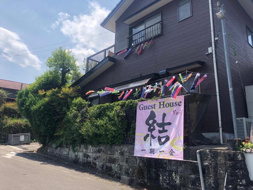 um sinal para uma casa de hóspedes em frente a uma casa em Guesthouse Yui em Hongu