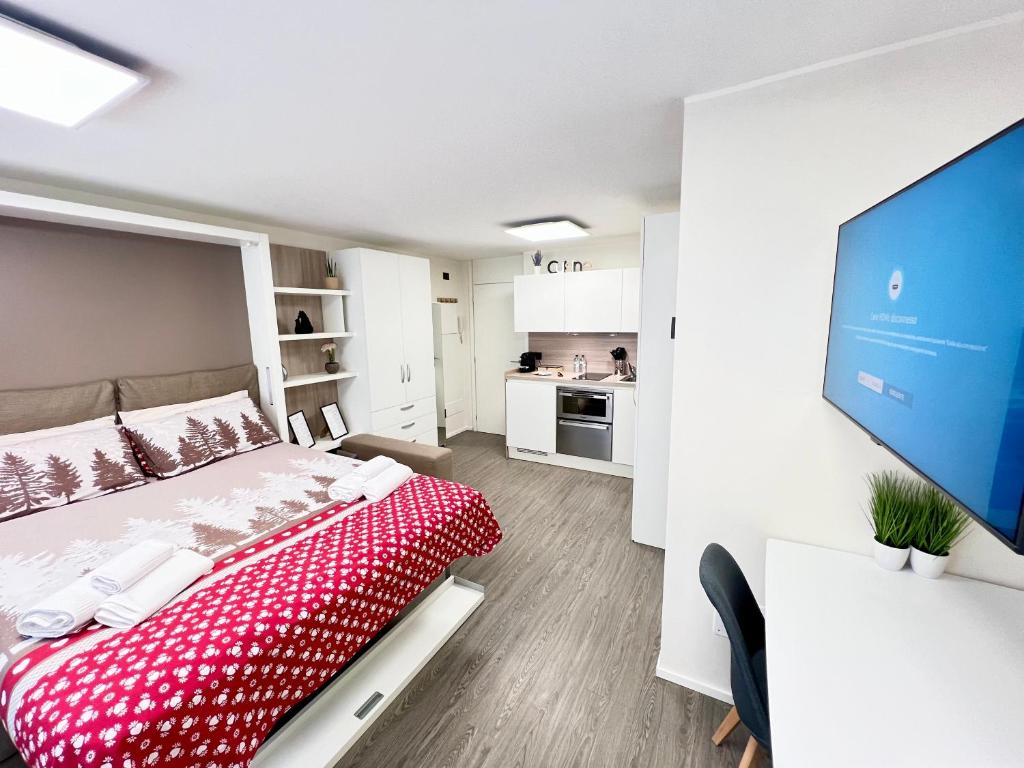 1 dormitorio con 1 cama y TV de pantalla plana en Il Nido delle Cime - 5 minuti a piedi dalle Terme - Parcheggio Gratuito, en Bormio