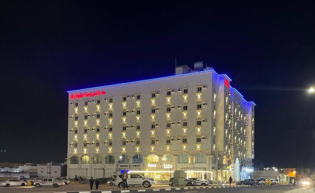 a large hotel with a red sign on top of it at سحاب الأندلس للأجنحة الفندقية - املج in Umm Lajj