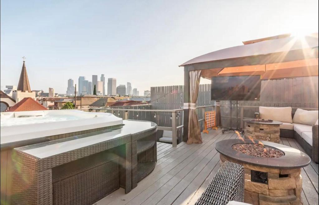 um deque no último piso com uma banheira e uma fogueira em Gorgeous DTLA w/ View + Hot Tub! em Los Angeles