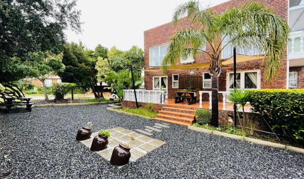 a house with threeotted plants in front of it at Plattekloof Premium Lodge in Plattekloof