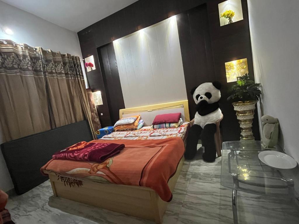 a bedroom with a panda bear standing next to a bed at Occasions in Jammu