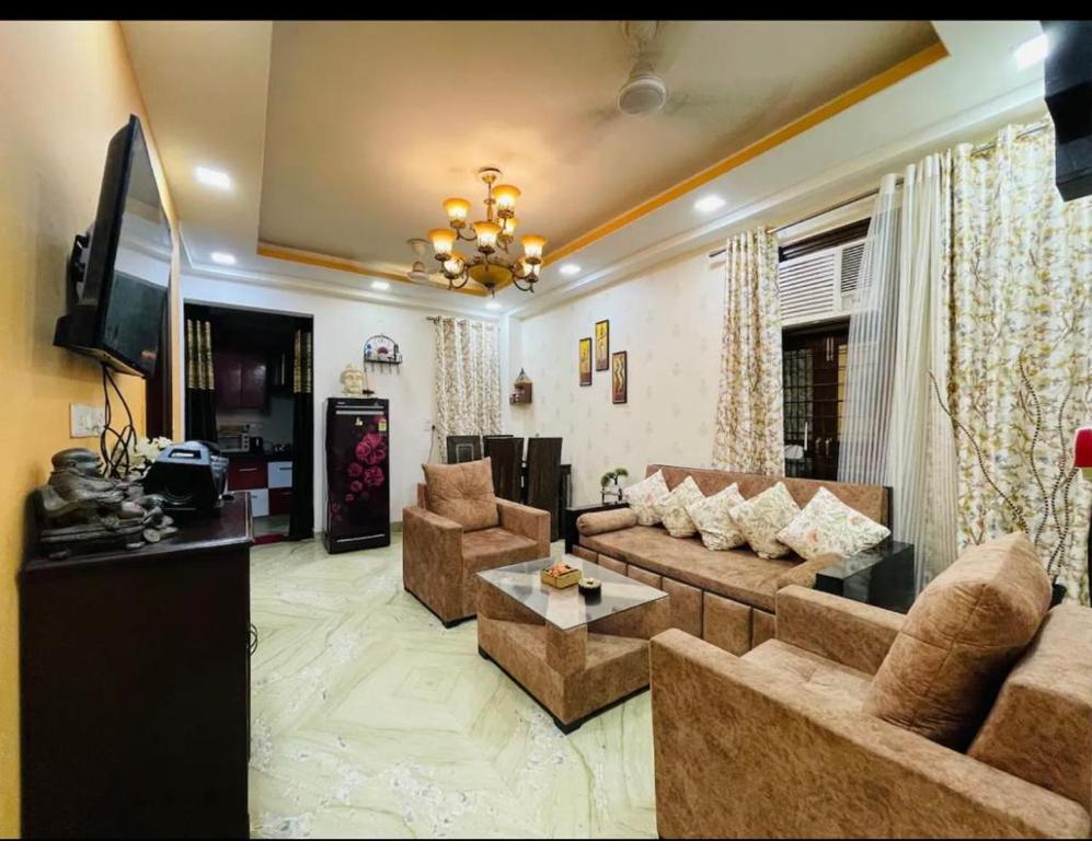 a living room with a couch and a tv at Aquila Home 2 BHK South Delhi Near Ashram Metro in New Delhi