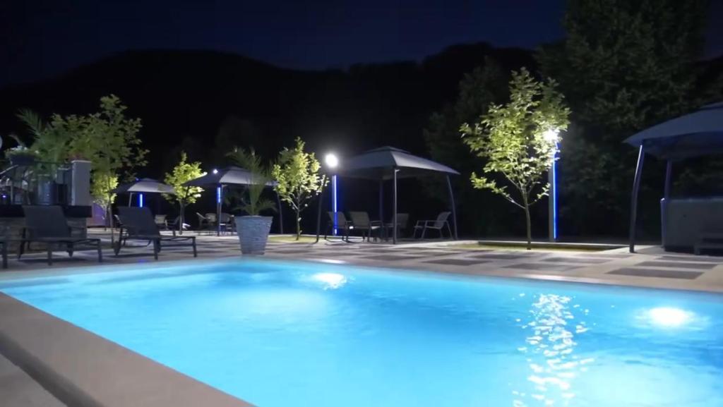 basen w nocy z krzesłami i parasolami w obiekcie Vila Casa cu Tei w mieście Lupeni